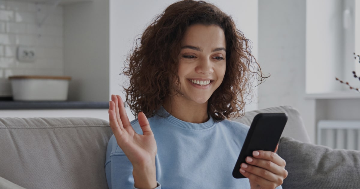 Mulher utilizando celular em chamada de vídeo, representando acesso e identificação digital relacionados à Chave J BB